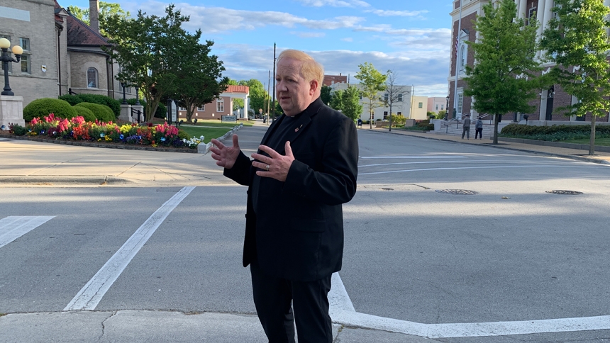 Father Tom Tully stands at the corner of New and Middle Streets in New Bern. (NC Catholics file photo 2021.)