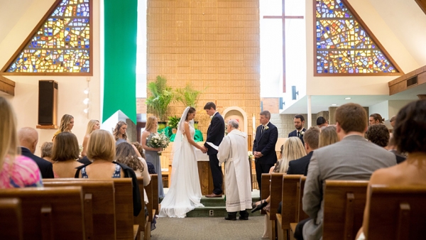 Lauren Smith and Josh Beil, who originally planned a Sept. 15 wedding in Morehead City, stand together during their wedding at Holy Infant Parish in Durham.